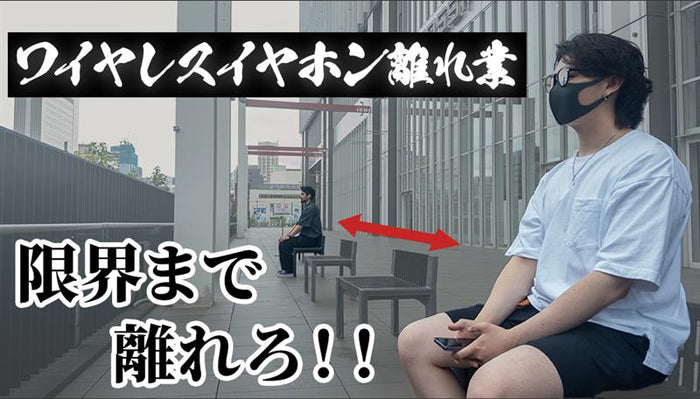 ワイヤレスイヤホンの通信距離の限界を検証するテスト風景。手前の男性はワイヤレスイヤホンを使用し、奥の男性と間に距離が設定されている。画面には「ワイヤレスイヤホン 離れ業」「限界まで離れろ!!」という挑戦的なキャッチコピーが表示されている。
