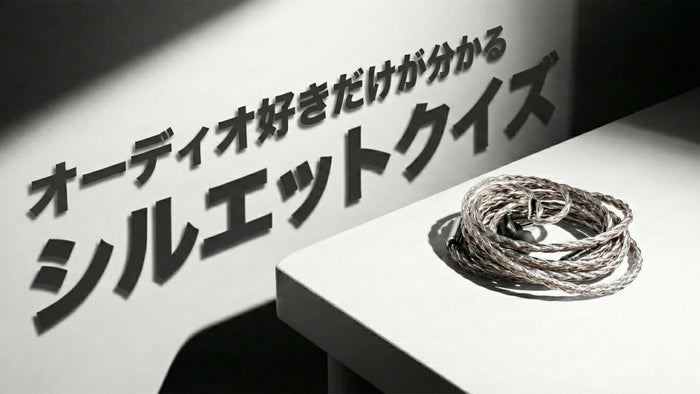 白い壁とテーブルの角を写したモノクロ風の画像。テーブルの上には、複数の線が編み込まれた光沢のあるオーディオケーブルが丸く束ねて置かれている。壁には「オーディオ好きだけが分かる シルエットクイズ」というテキストが、強い影と共に表示されている。
